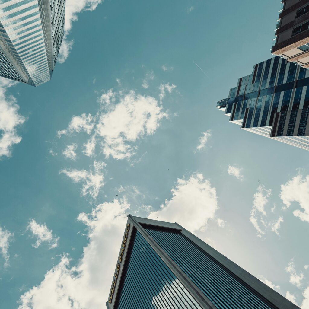 Dynamic view of Jacksonville skyscrapers reaching into a bright blue sky with clouds.